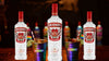Smirnoff Spicy Tamarind flavored vodka bottles with colorful cups in a bar setting.